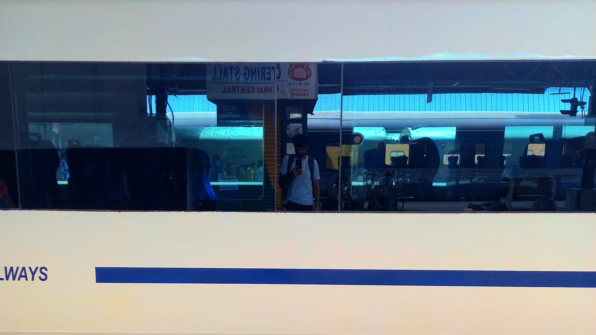 A self-photograph of Karthikeyan KC from the reflection on the windows of the Vande Bharat Express train.